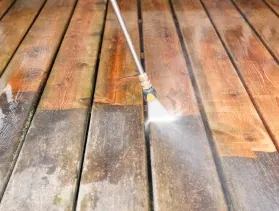 Timber deck half washed, the clean boards next to the grey ones