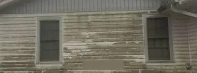 Weatherboard wall streaked with grime and mould before washing