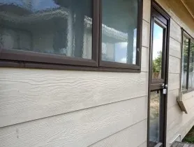 Clean weatherboards beside a dark aluminium window and door